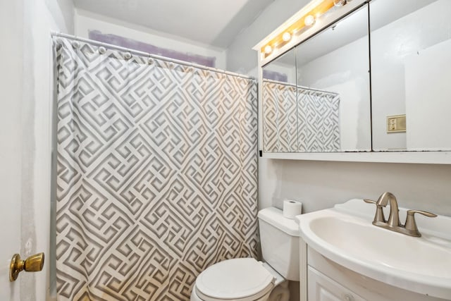 bathroom with walk in shower, vanity, and toilet