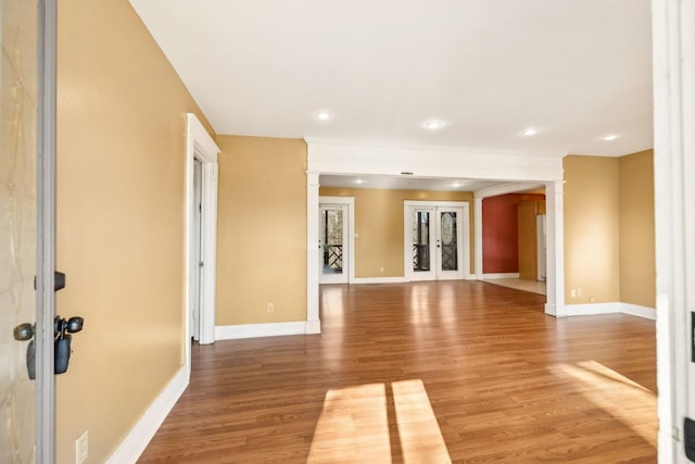 spare room featuring hardwood / wood-style floors, decorative columns, and french doors