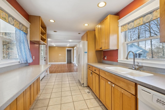 kitchen featuring sink, light tile patterned floors, and white appliances