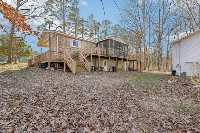 rear view of house with a wooden deck and a sunroom