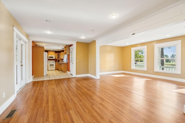 unfurnished living room featuring light hardwood / wood-style floors and decorative columns