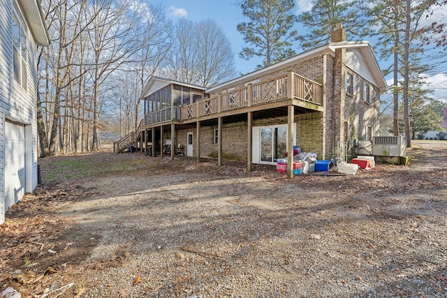 back of property featuring a wooden deck and a sunroom