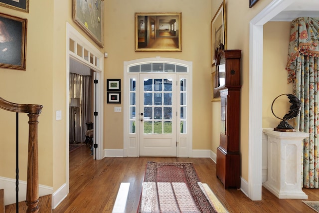 doorway with a high ceiling and hardwood / wood-style floors