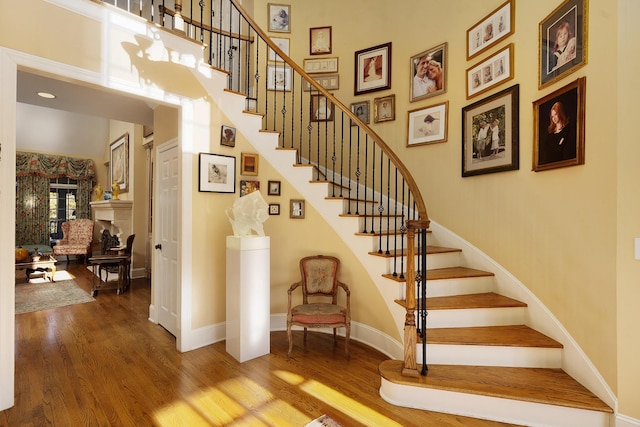 staircase featuring hardwood / wood-style flooring and a high ceiling