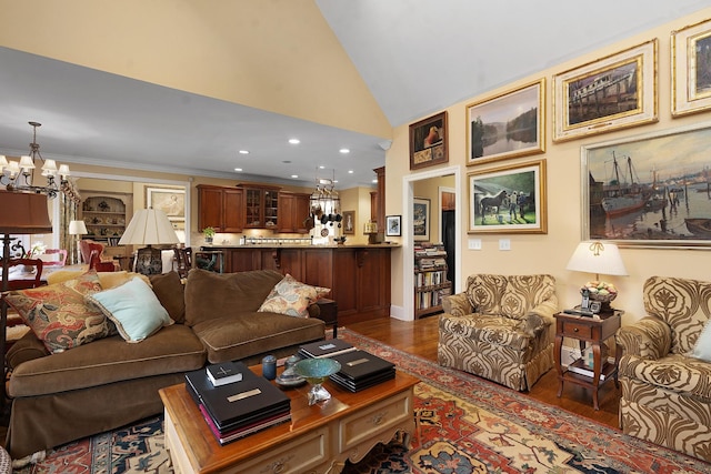 living room with an inviting chandelier, ornamental molding, lofted ceiling, and dark hardwood / wood-style floors