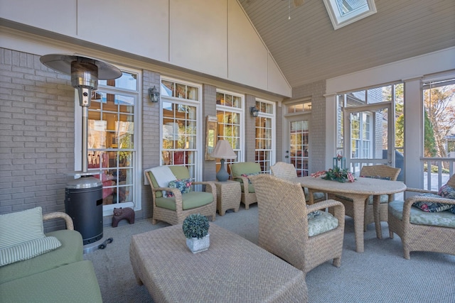 sunroom / solarium featuring lofted ceiling with skylight