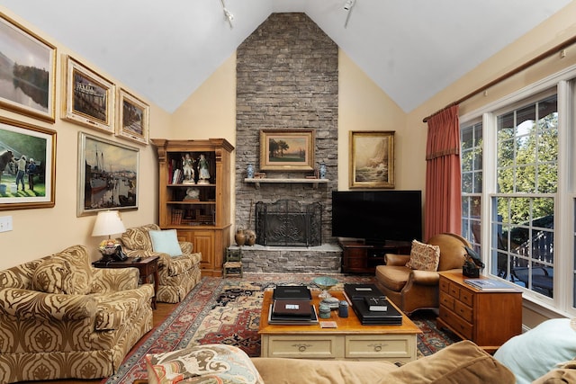 living room featuring a stone fireplace and high vaulted ceiling