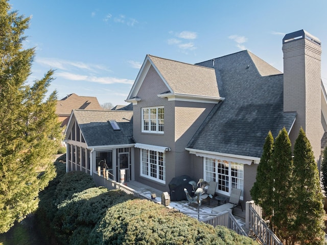 rear view of property featuring a patio and a sunroom