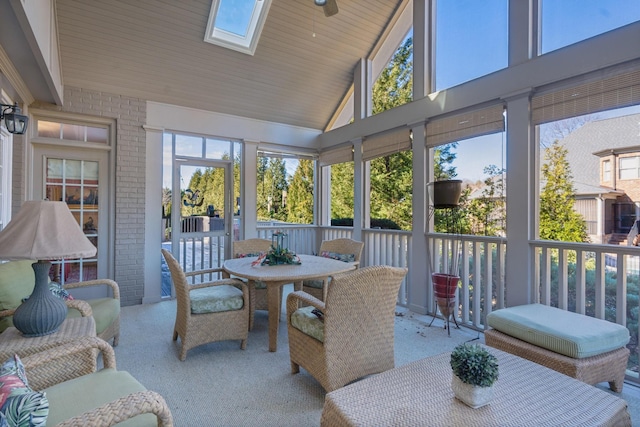 sunroom / solarium featuring lofted ceiling with skylight