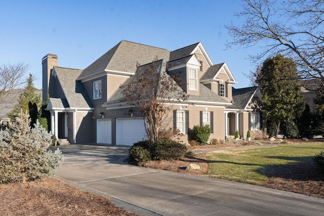 new england style home with a garage and a front yard