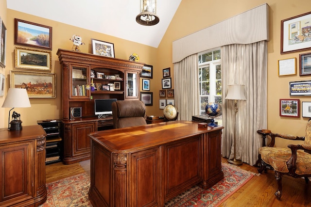 office space featuring light hardwood / wood-style floors and vaulted ceiling