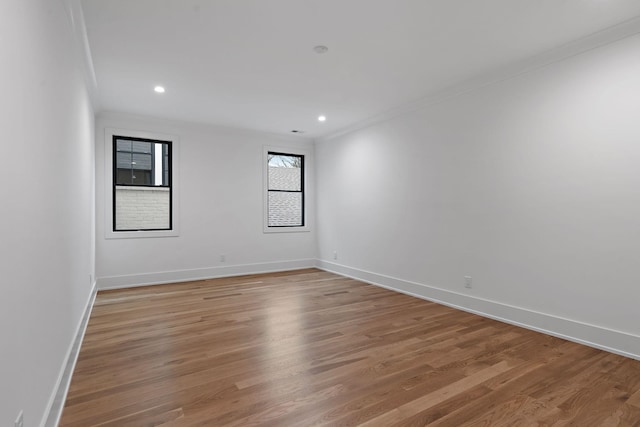 empty room with crown molding and light wood-type flooring