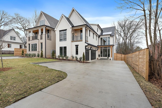 view of front of home featuring a garage, a front lawn, and a balcony