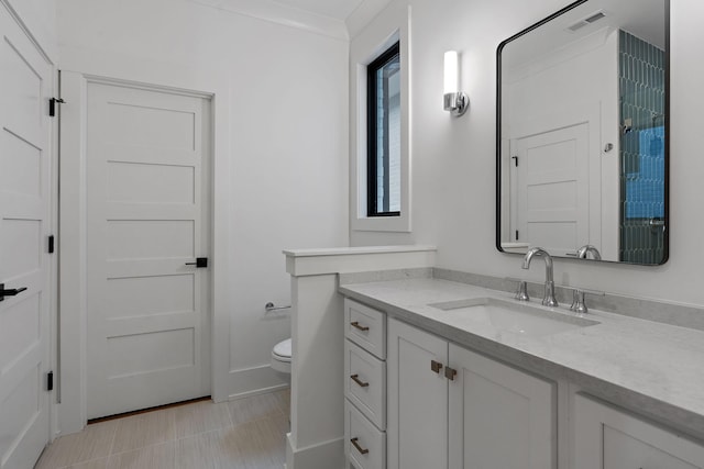 bathroom featuring vanity, crown molding, and toilet