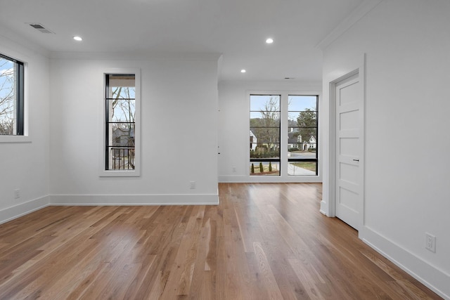 spare room featuring ornamental molding and light hardwood / wood-style floors