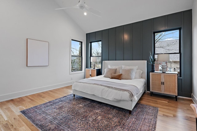 bedroom featuring ceiling fan, high vaulted ceiling, and light hardwood / wood-style flooring