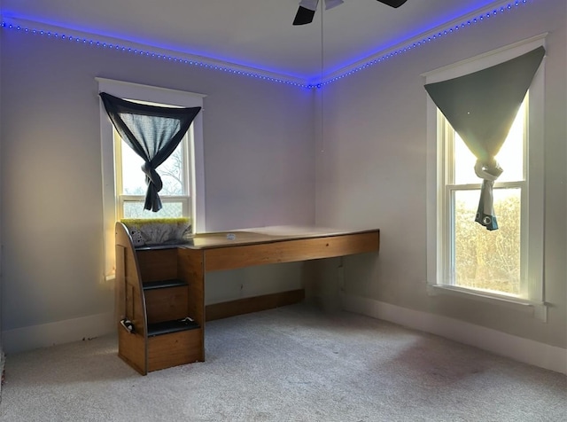 office area featuring ceiling fan, light colored carpet, and a healthy amount of sunlight