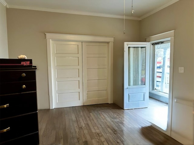 unfurnished bedroom with crown molding, hardwood / wood-style flooring, and a closet