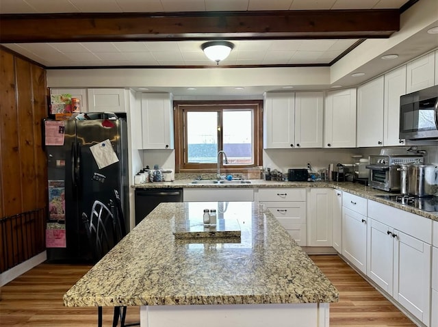 kitchen with a kitchen island, sink, white cabinets, and black appliances