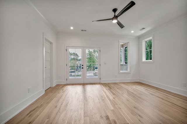 empty room featuring crown molding, ceiling fan, light wood-type flooring, and french doors