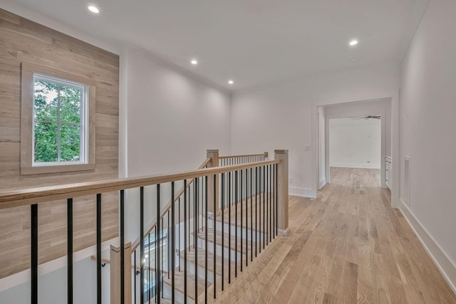 hallway featuring wooden walls and light hardwood / wood-style floors