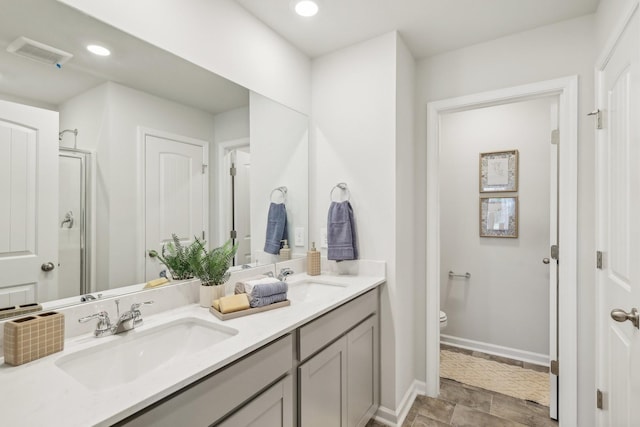 bathroom featuring vanity, toilet, and a shower with door