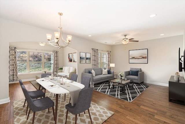 dining room featuring dark hardwood / wood-style flooring and ceiling fan with notable chandelier