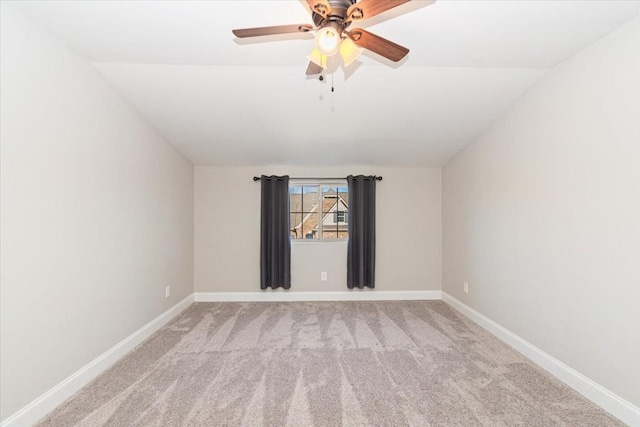 spare room with vaulted ceiling, light colored carpet, and ceiling fan