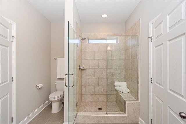 bathroom featuring tile patterned floors, toilet, and a shower with shower door