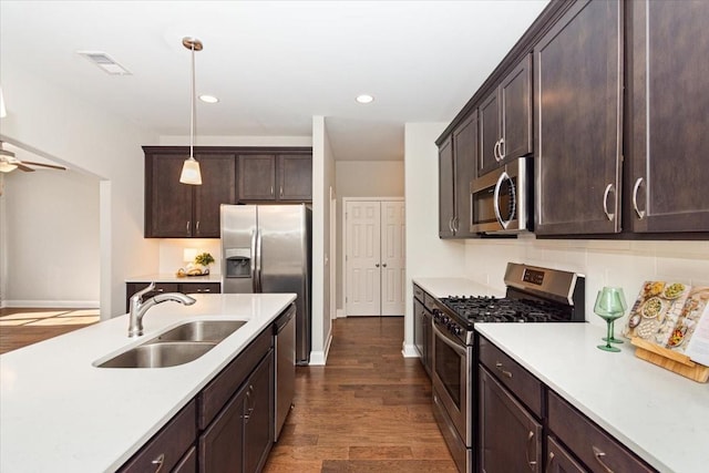 kitchen with appliances with stainless steel finishes, pendant lighting, sink, ceiling fan, and dark brown cabinets