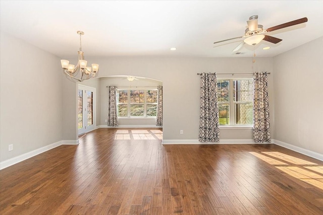 unfurnished living room featuring dark hardwood / wood-style flooring and ceiling fan with notable chandelier