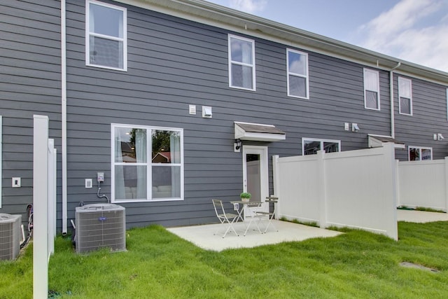 rear view of house featuring a yard, central AC unit, and a patio