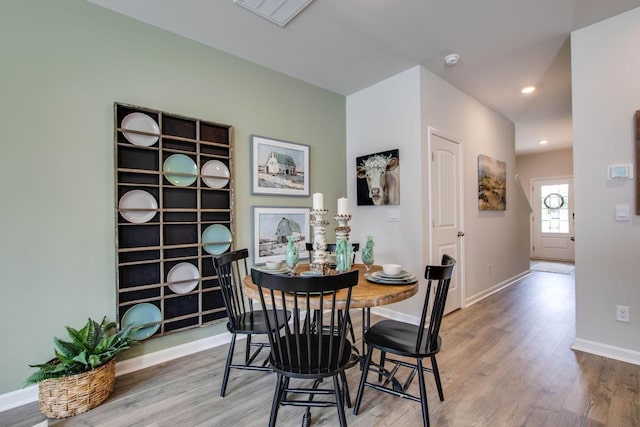 dining space with wood-type flooring