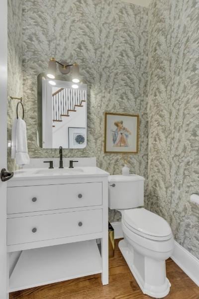 bathroom with hardwood / wood-style flooring, vanity, and toilet