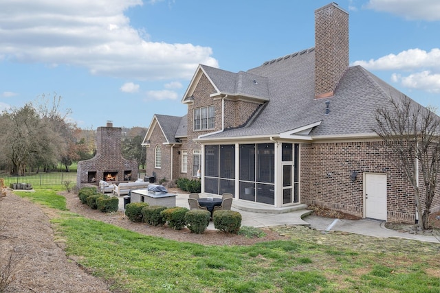 back of house featuring an outdoor fireplace, a patio, and a sunroom