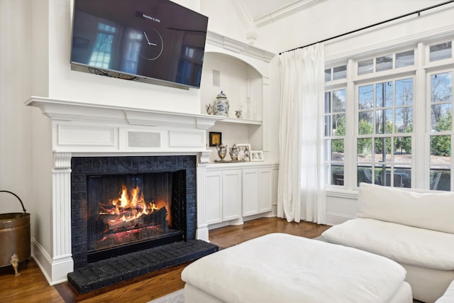 living room with crown molding, a healthy amount of sunlight, and dark hardwood / wood-style flooring