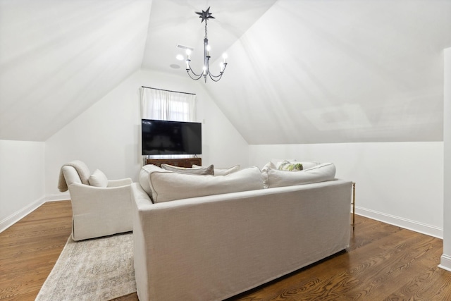 living room featuring lofted ceiling, hardwood / wood-style floors, and an inviting chandelier