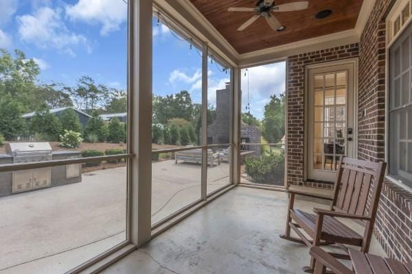 unfurnished sunroom with wooden ceiling and ceiling fan