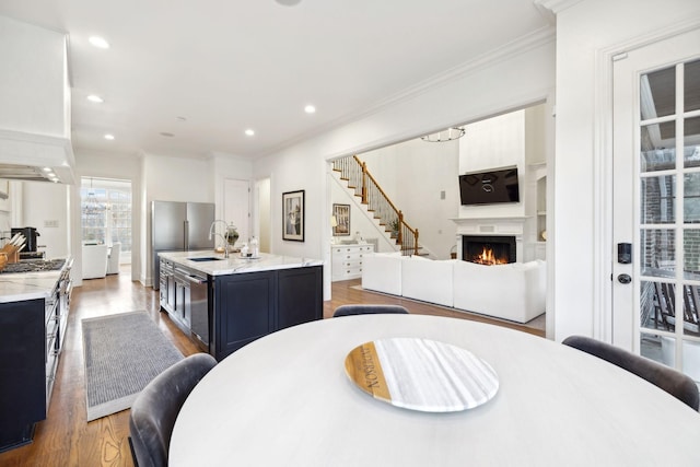 dining room with hardwood / wood-style flooring, crown molding, and sink