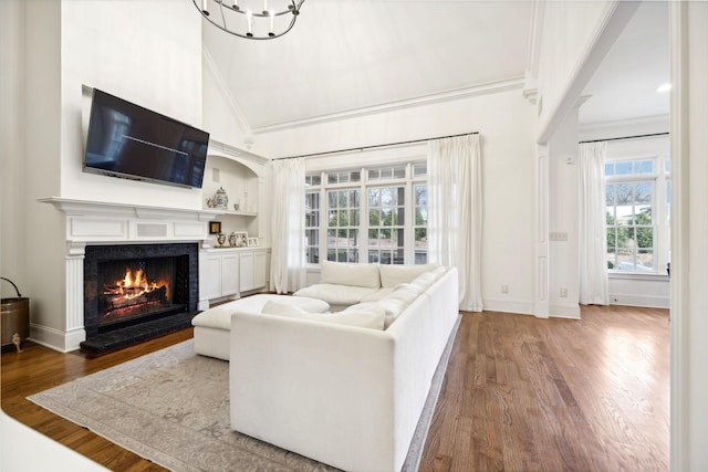 living room with hardwood / wood-style flooring, ornamental molding, high vaulted ceiling, and built in features