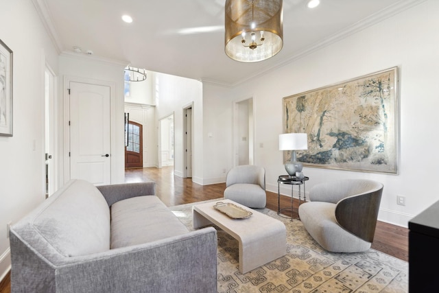 living room with crown molding, an inviting chandelier, and light wood-type flooring