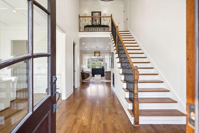 entryway with hardwood / wood-style flooring and a towering ceiling