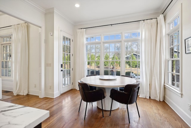 dining area with wood-type flooring and ornamental molding