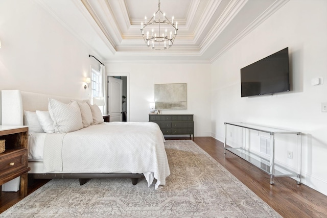 bedroom with hardwood / wood-style flooring, crown molding, a raised ceiling, and a notable chandelier