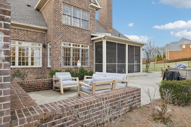 rear view of house with an outdoor living space, a patio area, and a sunroom