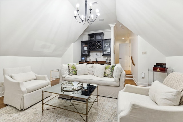 living room featuring hardwood / wood-style flooring, bar area, a chandelier, and vaulted ceiling