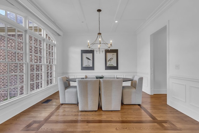 dining space with ornamental molding, light hardwood / wood-style floors, and a chandelier