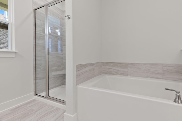 bathroom with hardwood / wood-style flooring and independent shower and bath