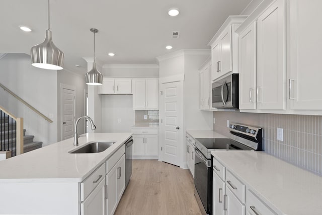 kitchen featuring sink, white cabinets, hanging light fixtures, a kitchen island with sink, and stainless steel appliances