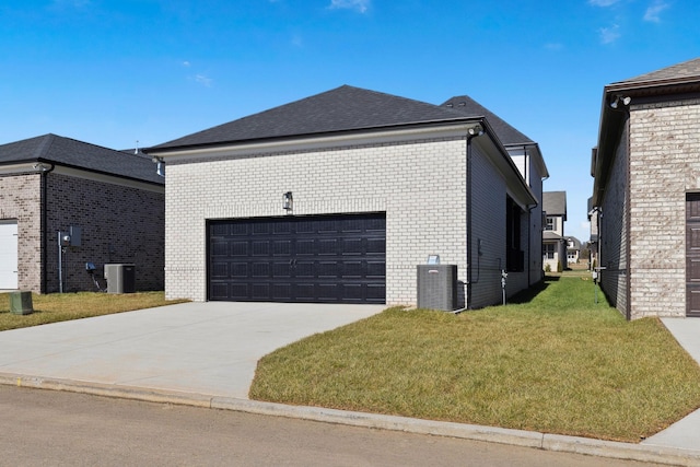 view of side of home with central AC unit, a yard, and a garage